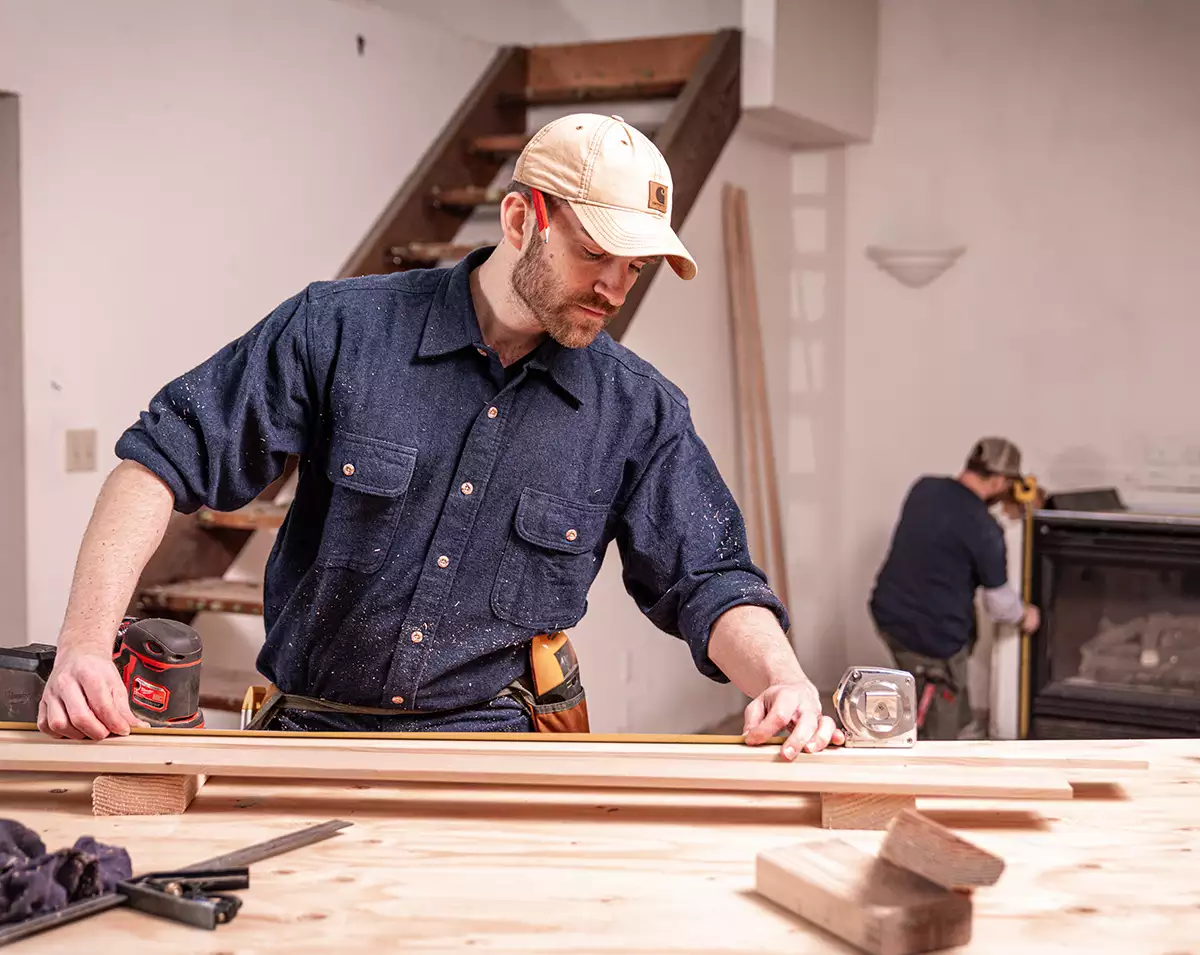 Worker Measuring a Board